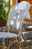 A designer rattan chair with grey and white plastic wickerwork