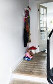 Eames Hang-It-All coat rack in renovated foyer with plain wooden floor