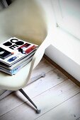 Stack of magazines on Plastic Armchair (Eames)