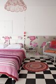 Schlafzimmer mit rundem Teppich auf Schachbrettmusterboden, Doppelbett mit weißem Holz Kopfteil und gestreiftem Plaid, vor Tapetestreifen an Wand