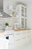 White, shabby-chic, Scandinavian kitchen with modern, stainless steel extractor hood