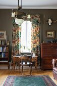 Rustic study with antique desk in front of window with pelmet and floor-length curtains