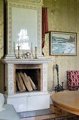 White-tiled, open fireplace with candlesticks on mantelpiece in traditional living room
