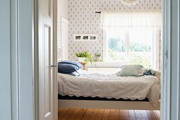 Bed with white lace bedspread in rustic interior