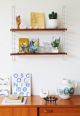 'String' shelves on wall above retro ornaments on partially visible sideboard