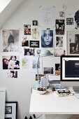 Retro-Tischleuchte auf Schreibtisch vor Wand mit Fotocollage und Bildern