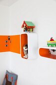 Regalbox mit orangefarbenen Innenflächen an Wand, seitlich Farbstreifen, im Kinderzimmer