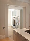 Blick von Küche durch offene Schiebetür auf modernen Wohnzimmer Regalschrank