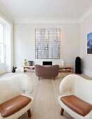 Extravagante Sessel mit weißem, fellartigem Bezug und Lederkissen im Wohnzimmer