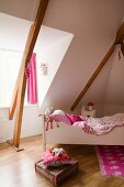 Girl's bedroom with white child's bed in converted attic