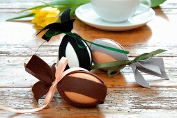 Easter decorations - eggs decorated with strips of dark felt on rustic wooden surface