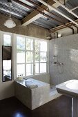 Rustic bathroom with tiled shower area next to large window below exposed utility lines in ceiling space