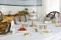 Table set with cheese, bread and tomatoes in Scandinavian, country-house kitchen
