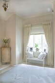 Elegant, country-house-style bedroom - view across double bed to delicate wooden bench below window