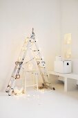 Alternative Christmas tree made from folding ladder and take-away cartons used as candle lanterns