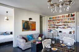Wohnen auf kleinem Raum, mit elegantem Essplatz, Homeoffice-Regal und gestreiftem sofa, seitlich Zugang ins Schlafzimmer