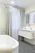 Bodenlange Vorhänge und schwarz-weisser Mosaikboden in elegantem Badezimmer