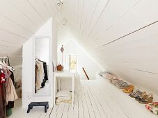 Attic dressing area with white-painted wooden floor, dormer window and mirror