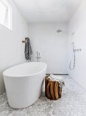 Barrierefreies minimalistisches Designer-Duschbad mit freistehender weißer Badewanne und rustikalem Holzhocker