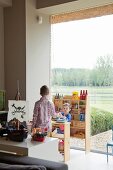 Children playing in front of panoramic window in living area