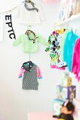 Children's clothing hung on wall and from line