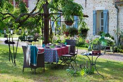 Set garden table, wicker and metal chairs, vintage candle lanterns and candlesticks
