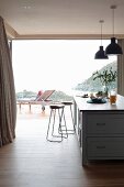 View past two bar stools at kitchen counter to lounger on terrace
