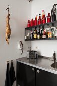 Black kitchen with shelves, retro toaster and ham hanging from butchers' hook