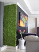 Strip of green fluffy fabric on wall next to bouquet on white side table below artwork on black wall in living room