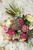 Bouquet of roses and protea on vintage wooden surface