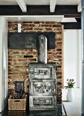 Industrial-style wood-burning stove against old brick wall