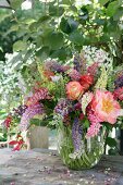 Summer bouquet of lupins, roses and gloriosa lilies in glass vase