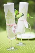 Paper napkins hand-stamped with fern motifs in wine glasses