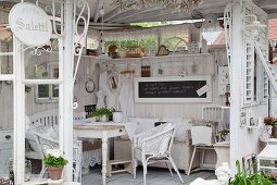 Shabby-chic summer house with pale furniture and flea-market accessories