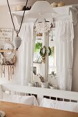Window decorated with white lace curtains and old, adjustable pendant lamps with white china lampshade