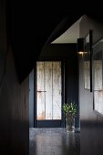 Dunkel gestrichener Flur mit einer alten Holztür