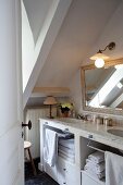 Blick ins Badezimmer mit Dachschräge und doppeltem Waschtisch mit Marmorplatte