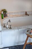 Vintage-style bathtub with marble surround and board facing