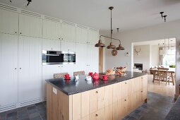 Island counter in rustic kitchen with white and plain wooden cabinets