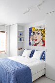 Doppelbett mit blauer Tagesdecke, darüber Pop-Art Kunstdruck, Roy Lichtenstein, in modernem Schlafzimmer in Weiß