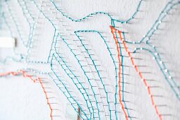 Stylised string-art map on white wall (detail)