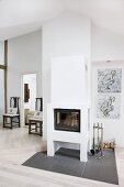 Grey tiled area around masonry log-burner, modern drawings on wall and dark antique chairs in background