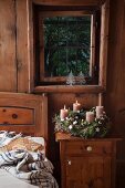 Rustic Advent wreath with two lit candles in rustic bedroom