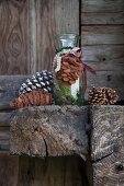 Fir cone hand-crafted from brown felt tied to glass bottle