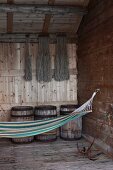 Hammock hanging from hook in rustic wooden wall