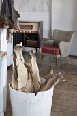 Dried fish in whitewashed wooden tub in front of fifties armchair in rustic interior