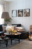 Christmas decorations on tray table, black leather sofa and photos on wall