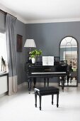 Black piano and stool on white wooden floor