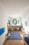 Blue rug on floor of child's bedroom with elephant figure and toy car