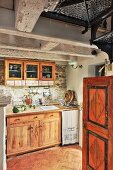 Solid wooden kitchen cabinets on stone walls in vintage-style interior